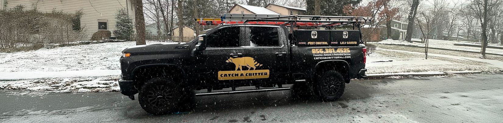 Catch A Critter work truck parked on a snowy South Jersey street